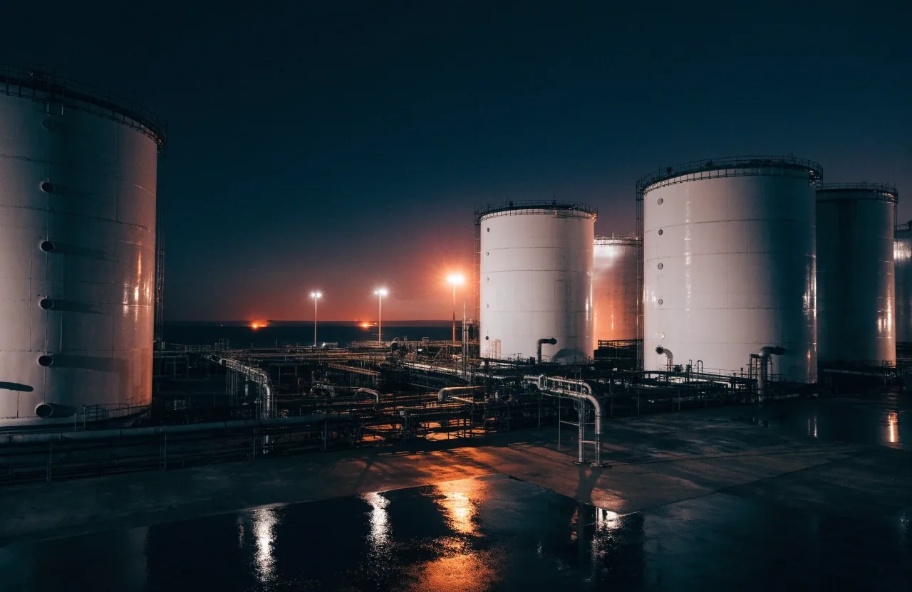 A gas flare burning over an oil terminal at night