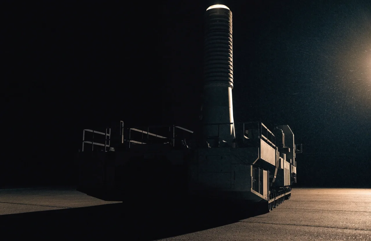 An unmarked mobile missile launcher on a floodlit concrete apron at night